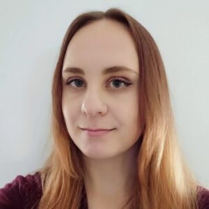 Kasmira Geering wearing a red shirt smiling at the camera.