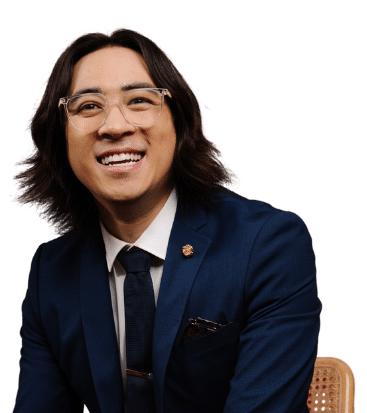 Michael Hing, wearing navy suit, glasses and with shoulder-length hair