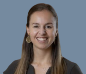 Image of Shelley, wearing a dark brown shirt, has long brown hair and is smiling at the camera
